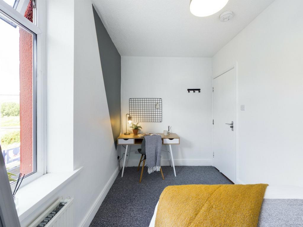 A bright and tidy double bedroom featuring a st...