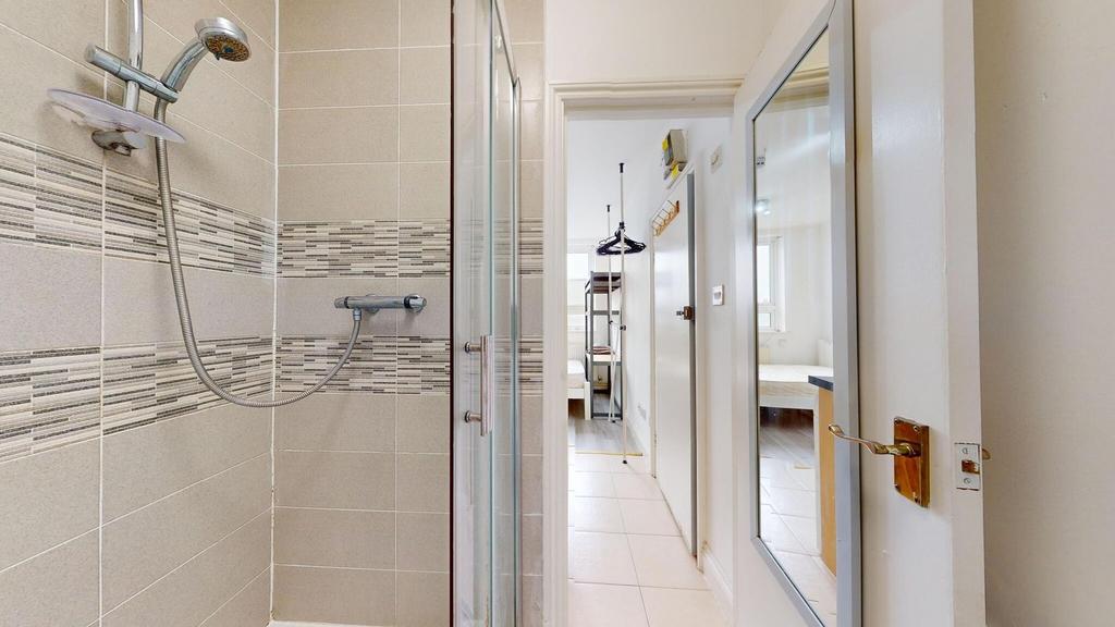 Modern bathroom featuring a shower with beige t...