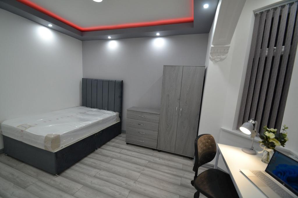 A modern, well-lit bedroom featuring a stylish ...