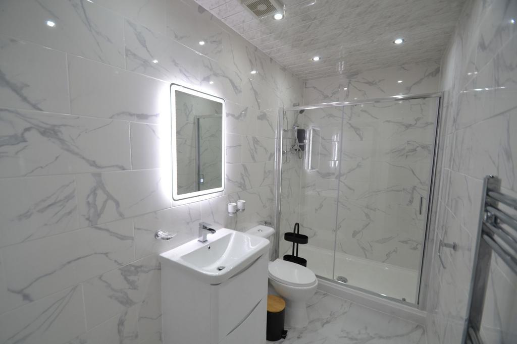 Modern and sleek bathroom with large marble-eff...