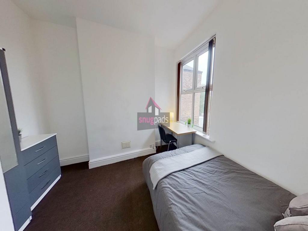 Bright, simply furnished bedroom with a single ...