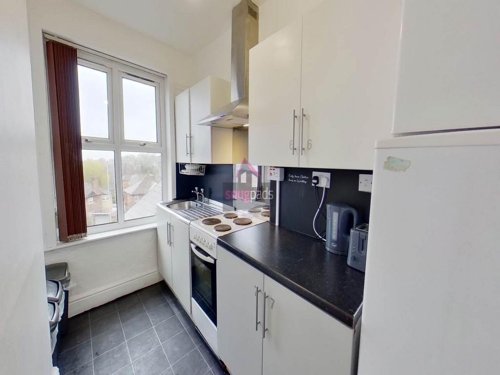 Bright, modern galley kitchen with white cabine...