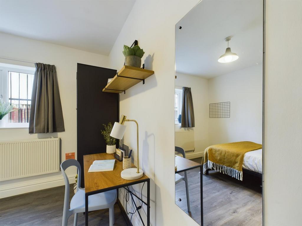 A bright and tidy double bedroom featuring a wo...