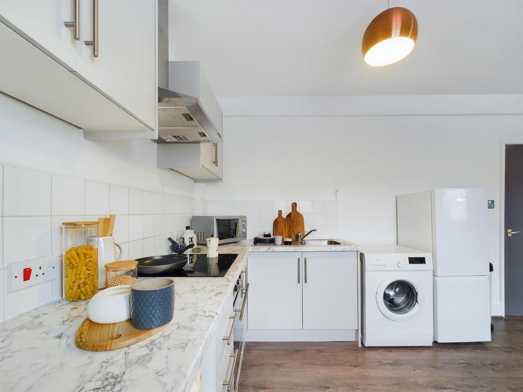 A modern and clean kitchenette with ample stora...