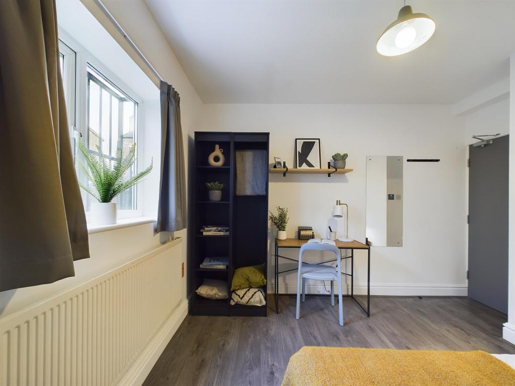 A bright and inviting double bedroom with a stu...