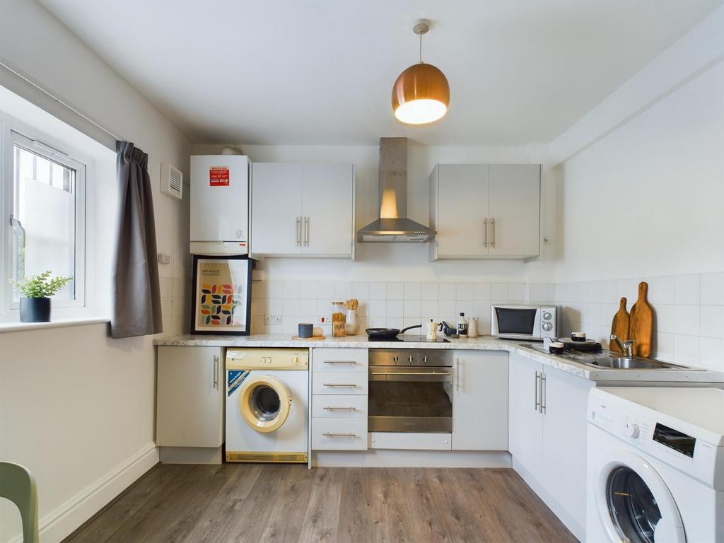A bright and modern kitchenette with ample stor...