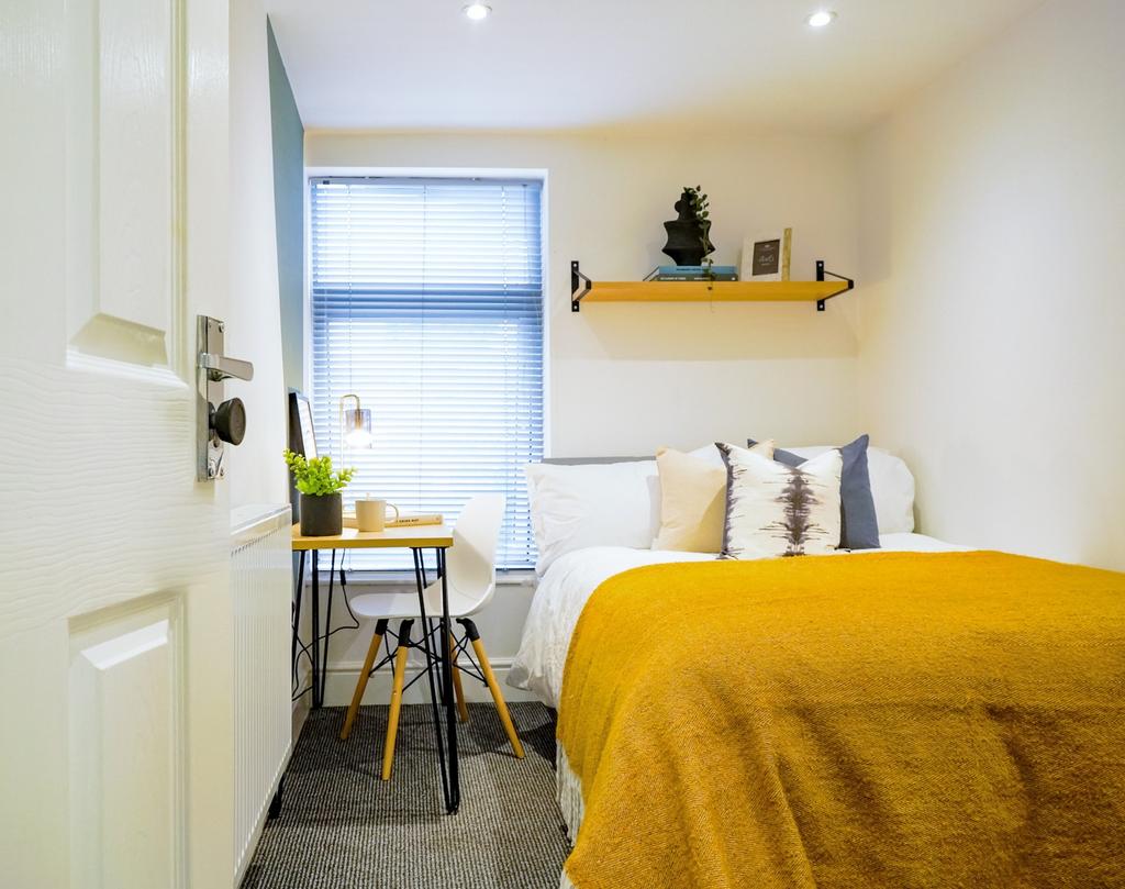 A cozy and well-lit double bedroom featuring mo...