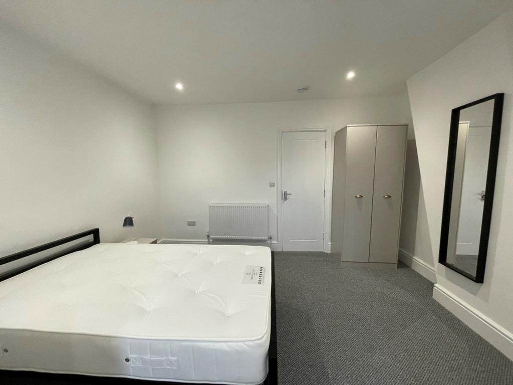 A spacious and well-lit double bedroom, perfect...
