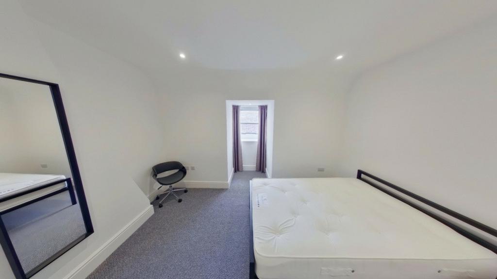 A spacious and clean double bedroom with ample ...