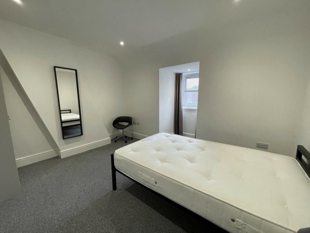 A spacious and well-lit double bedroom perfect ...