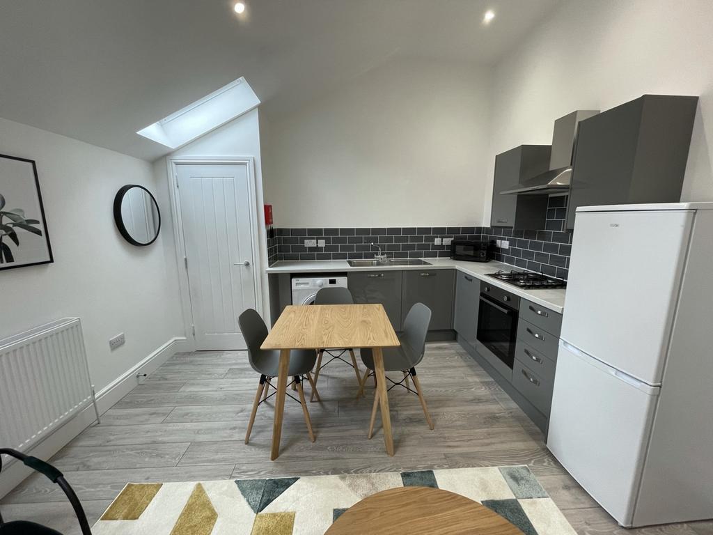 A bright and modern kitchenette with ample spac...