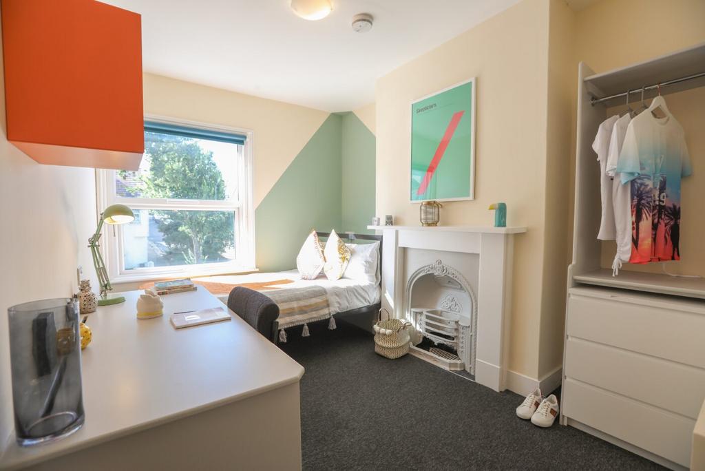 Bright, welcoming bedroom featuring a comfortab...