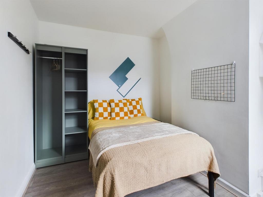A bright and tidy double bedroom featuring mode...