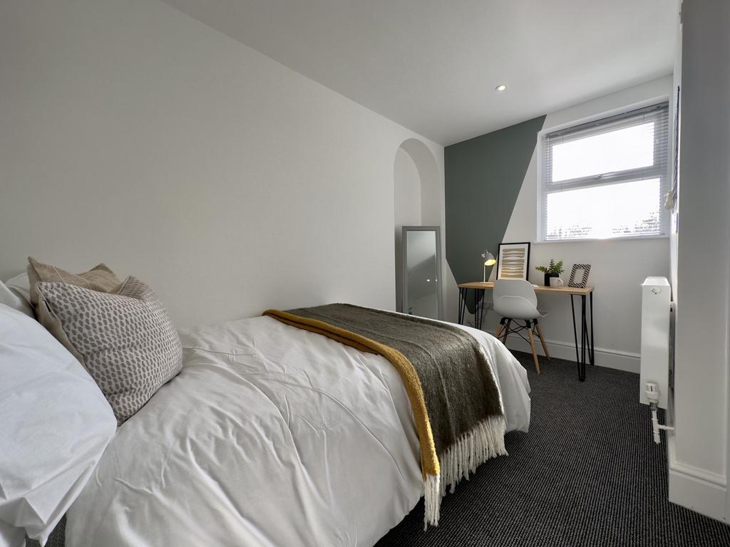 A bright and tidy double bedroom featuring a co...