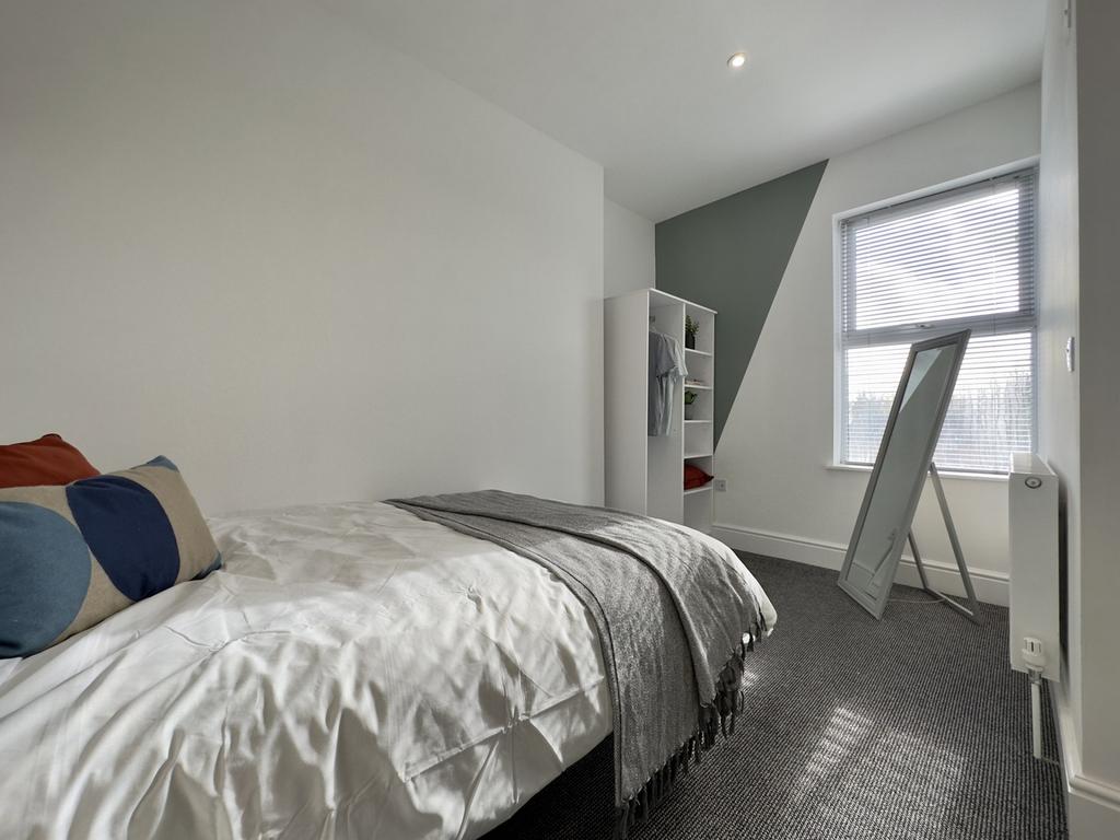 A spacious and bright double bedroom featuring ...