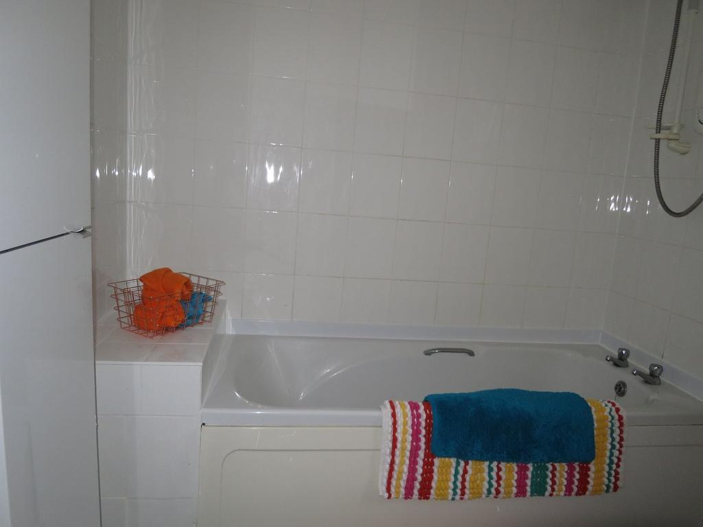 Bright tiled bathroom with a built-in bathtub, ...