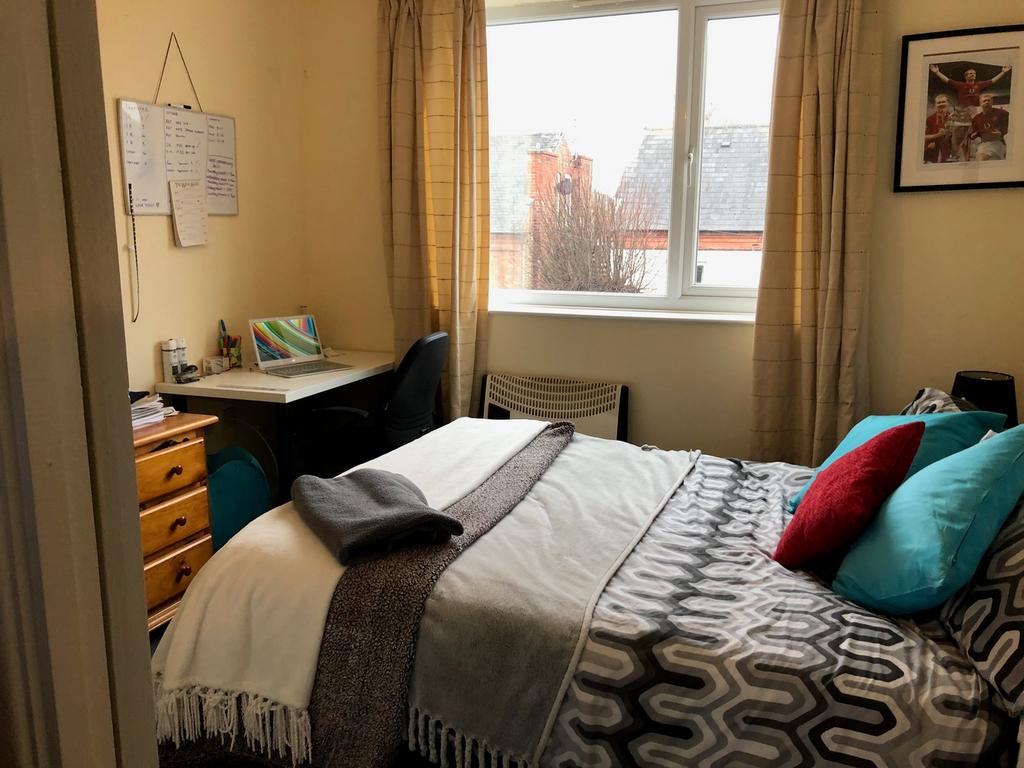 A cozy and well-lit double bedroom with ample s...