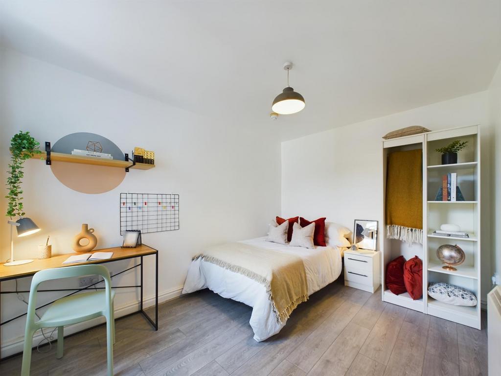 This inviting double bedroom features a cozy be...