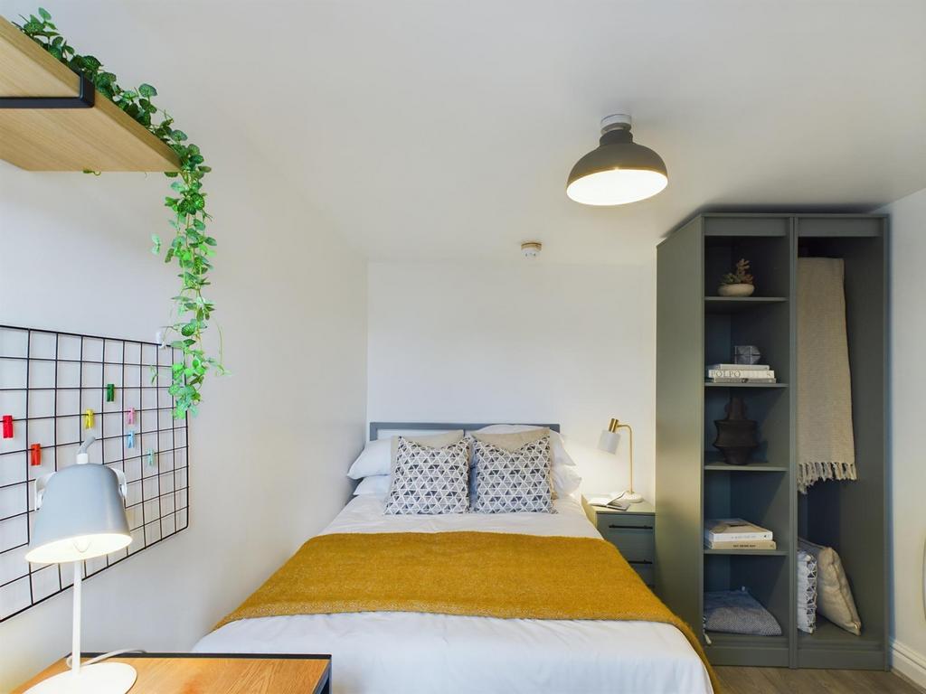 This inviting double bedroom features a cozy be...