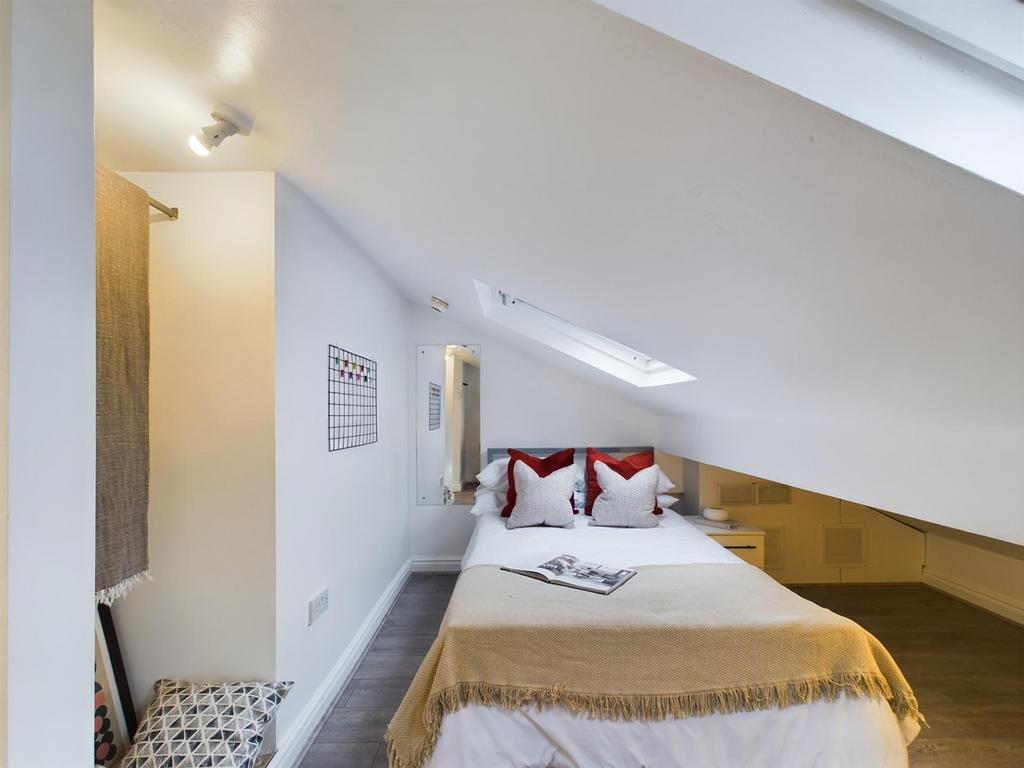 A cozy double bedroom featuring sloped ceilings...