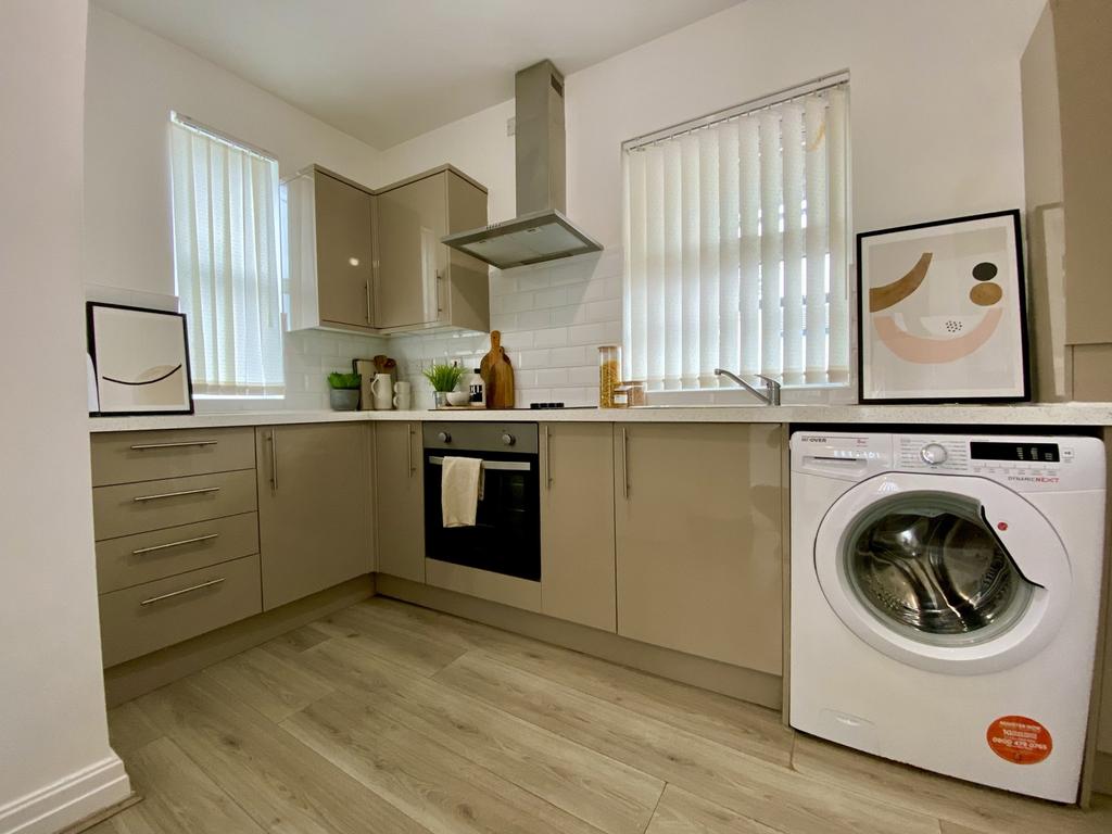 A modern and tidy kitchenette with ample storag...