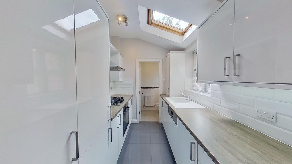 Bright, modern galley kitchen with sleek white ...