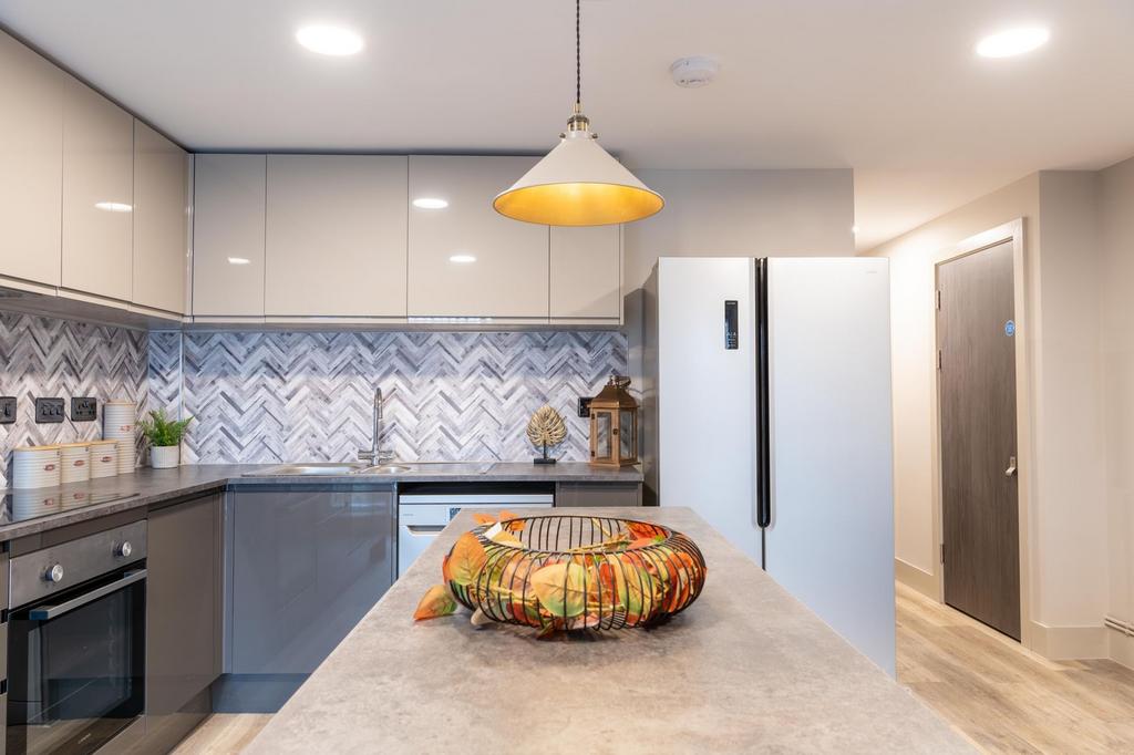 Modern kitchen featuring a sleek design with gl...