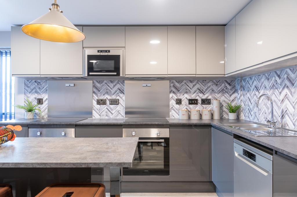 This modern kitchen features sleek cabinetry, s...