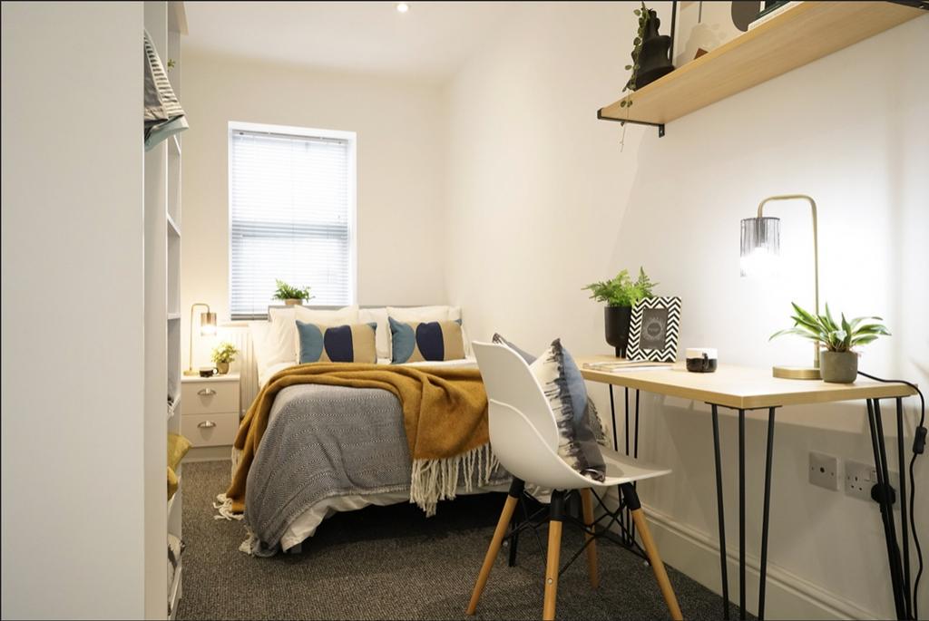 A bright and stylish double bedroom featuring a...