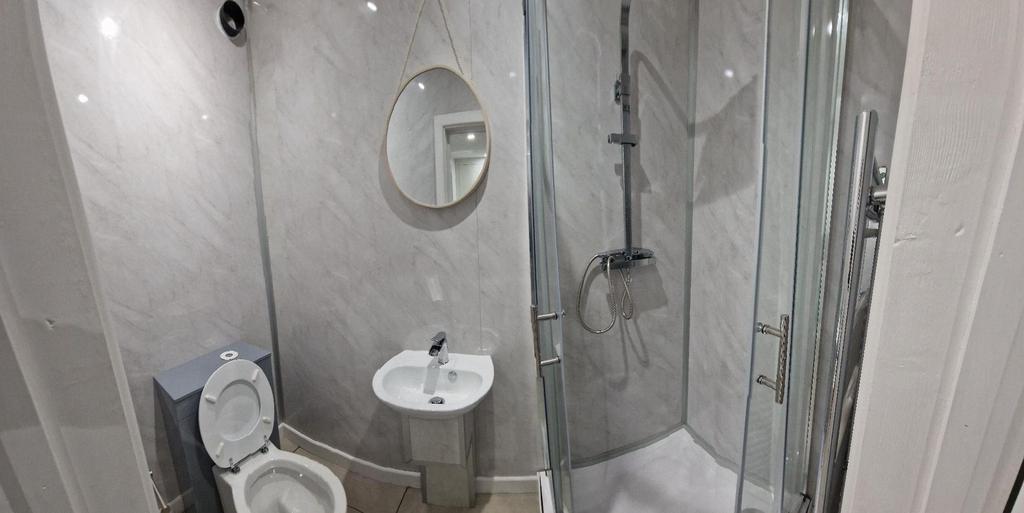 Bright, modern bathroom with a glass corner sho...