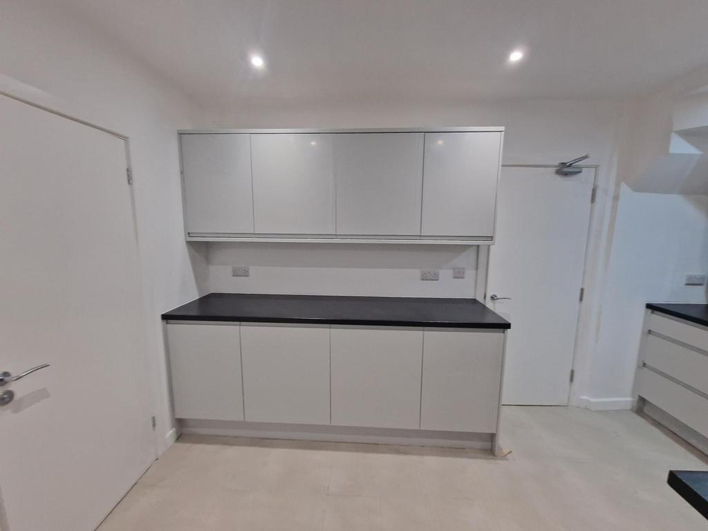 Modern, minimal kitchen with sleek grey cabinet...