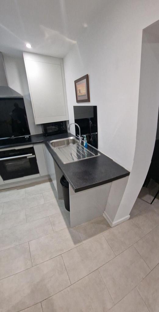 Modern galley-style kitchen with a stainless st...