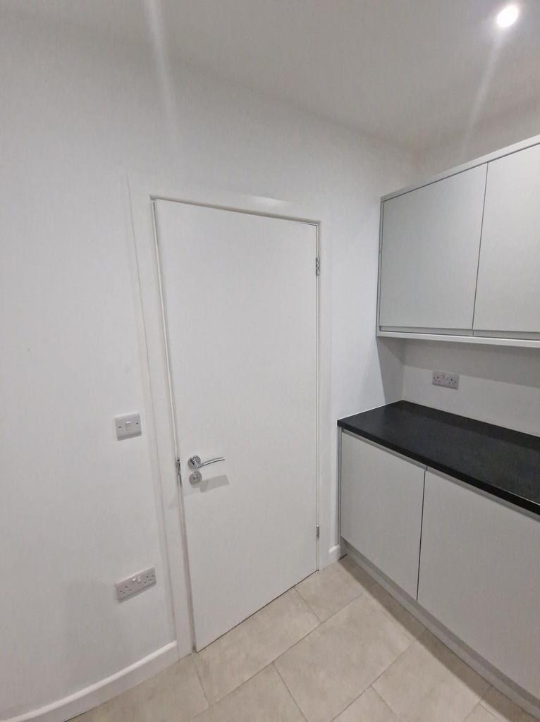 Bright modern kitchen area with sleek grey cabi...