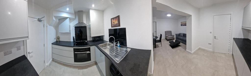 Bright modern kitchen with sleek black countert...