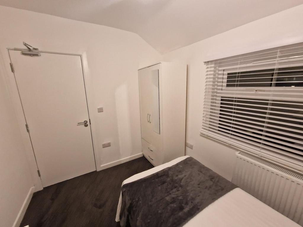 Neat, simply furnished bedroom with a comfortab...
