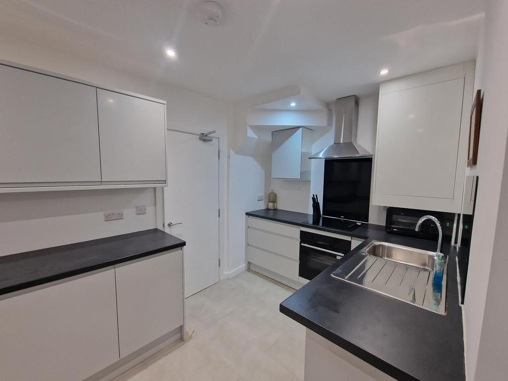 Modern fitted kitchen with sleek black worktops...