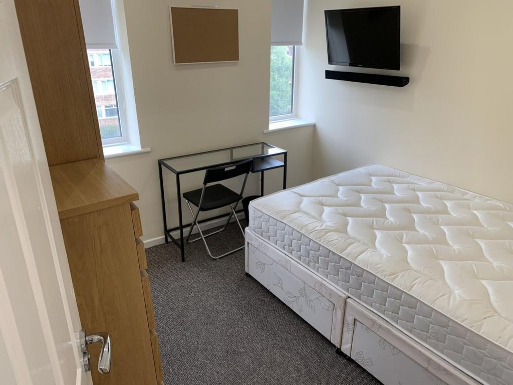 A bright and tidy double bedroom featuring a de...