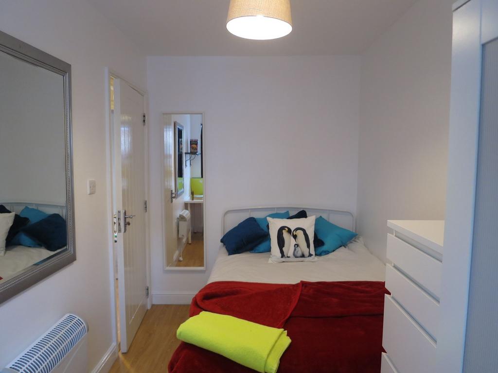 Bright, neatly presented bedroom featuring a co...