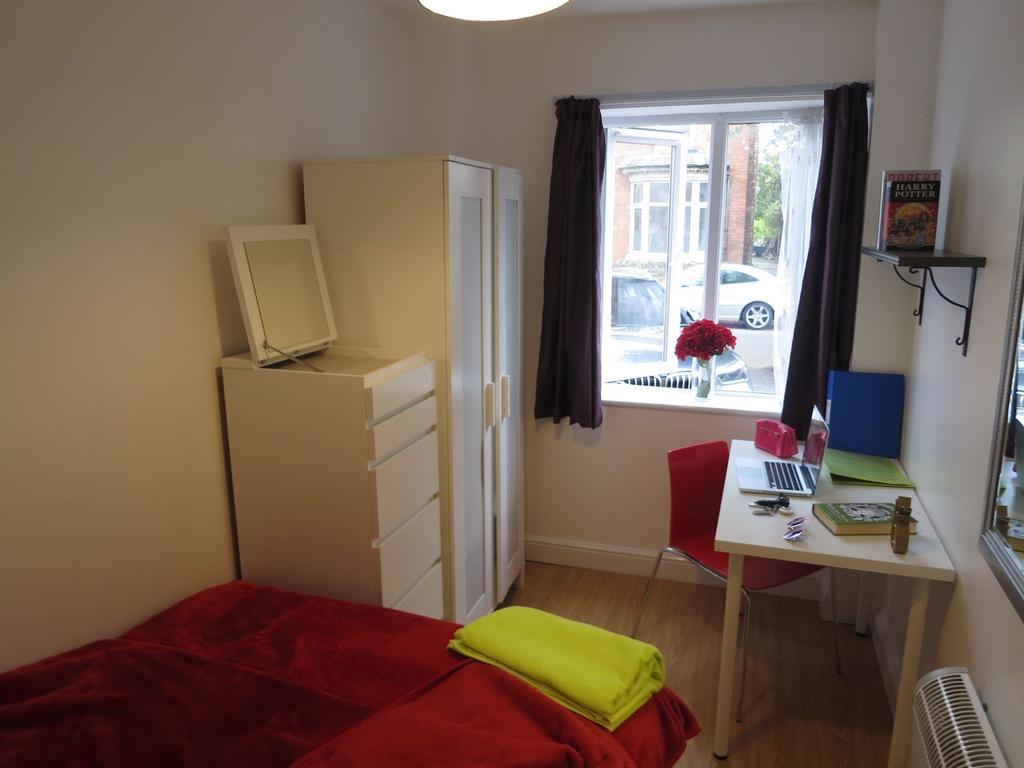 Bright, neatly furnished single bedroom with a ...