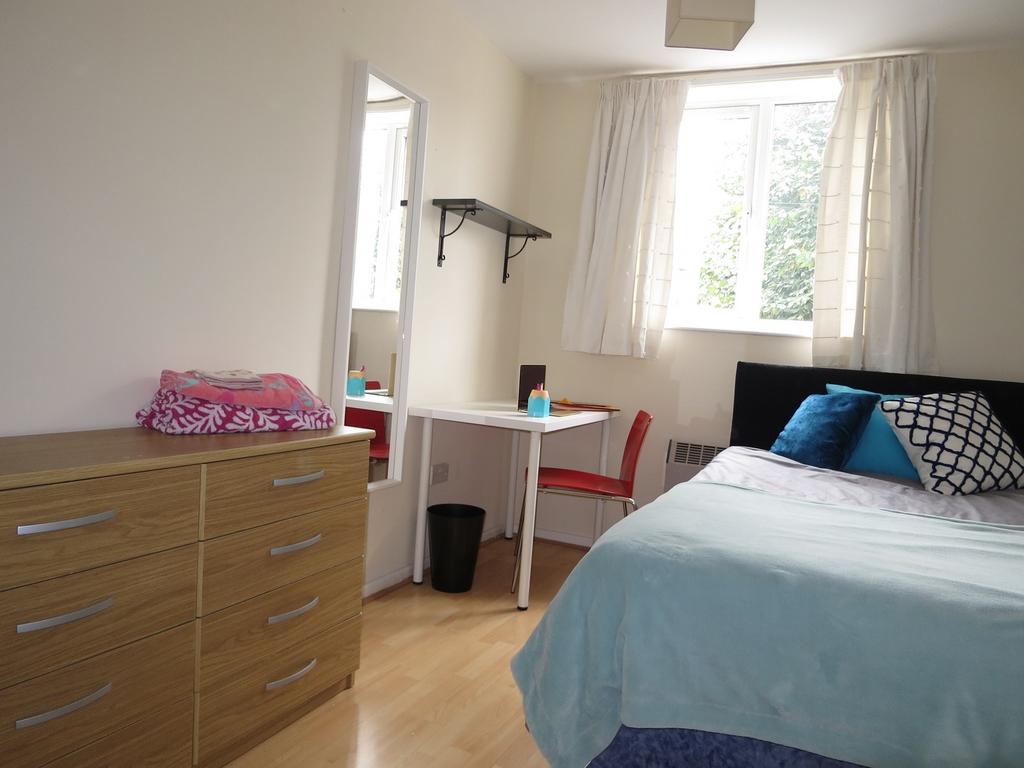 A bright and inviting double bedroom with a com...
