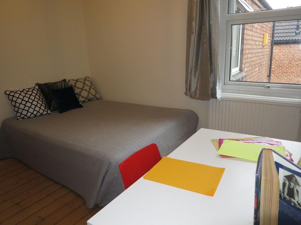 Bright, simply styled bedroom with a neatly mad...