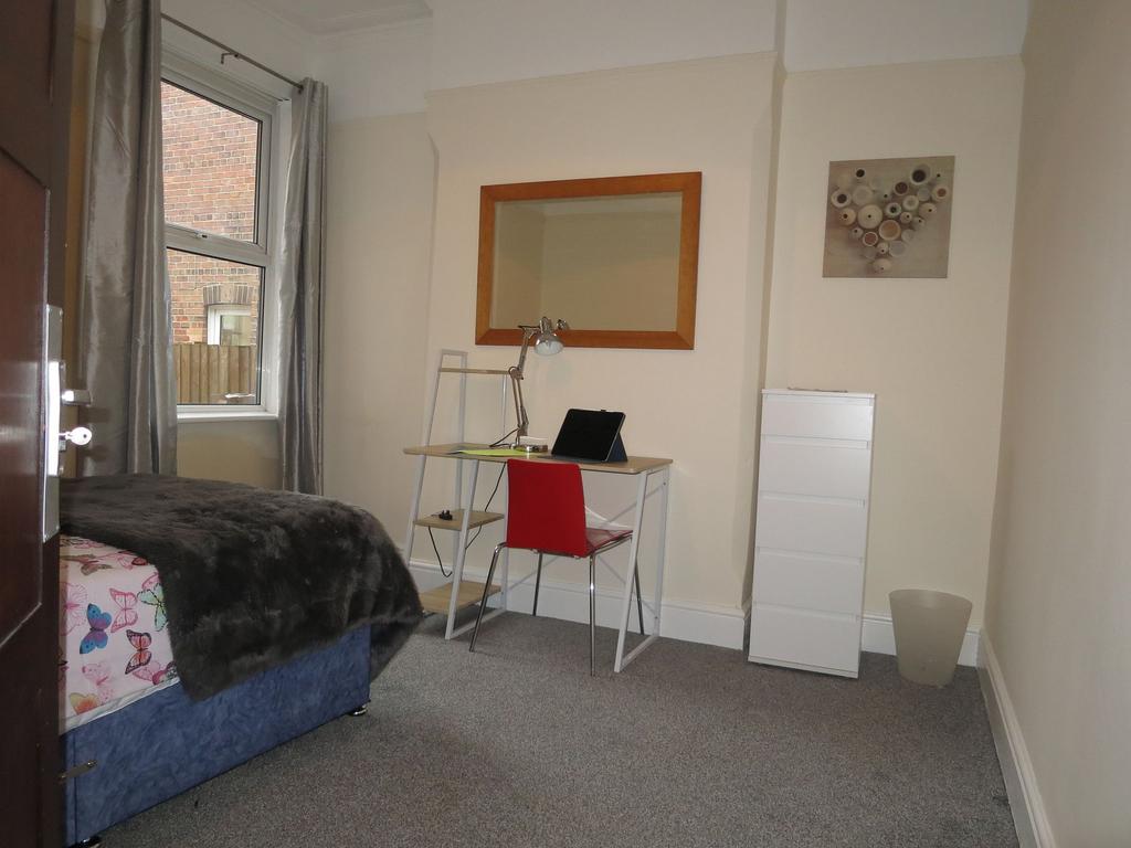 Bright, neatly presented bedroom with a study d...