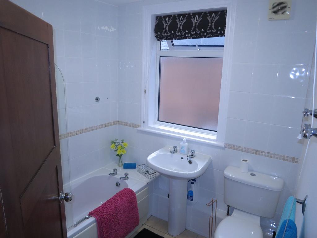 Bright, well-maintained bathroom with a white p...