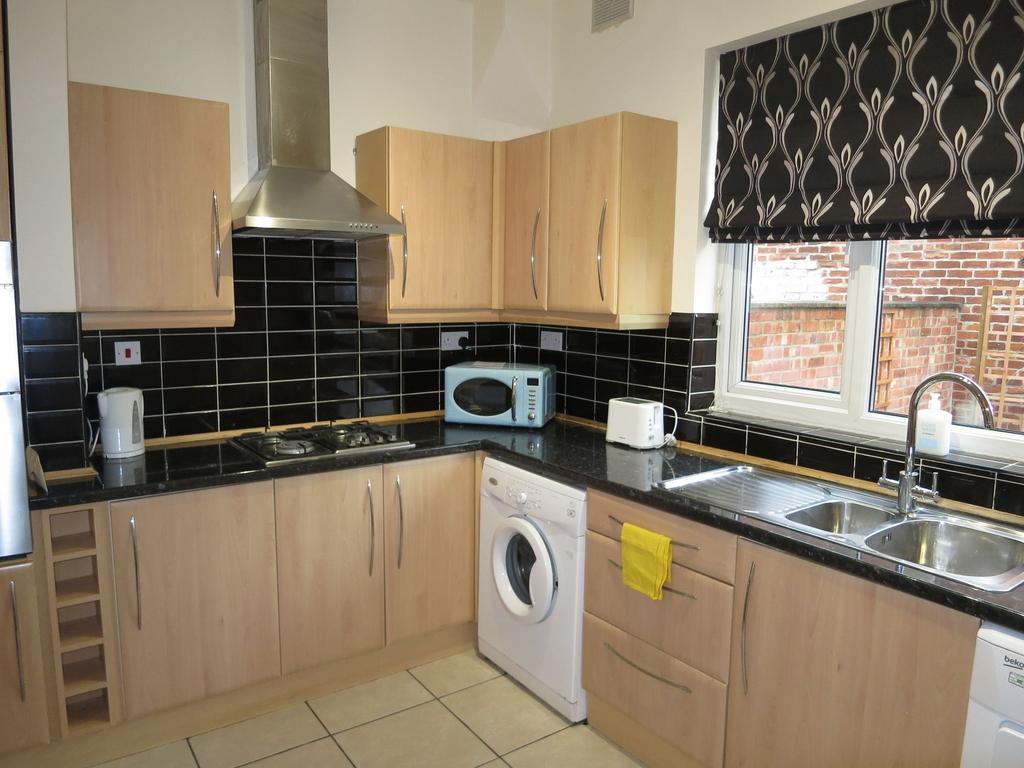 Contemporary fitted kitchen with light wood cab...