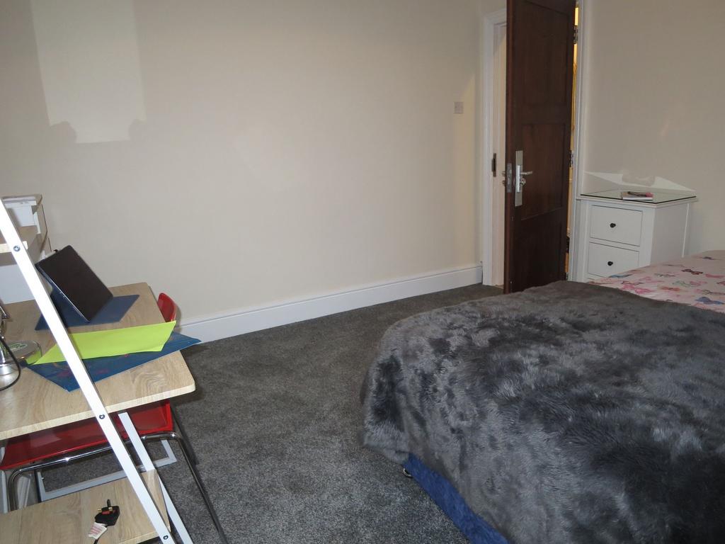 Well-kept bedroom with cosy bedding, a desk wor...