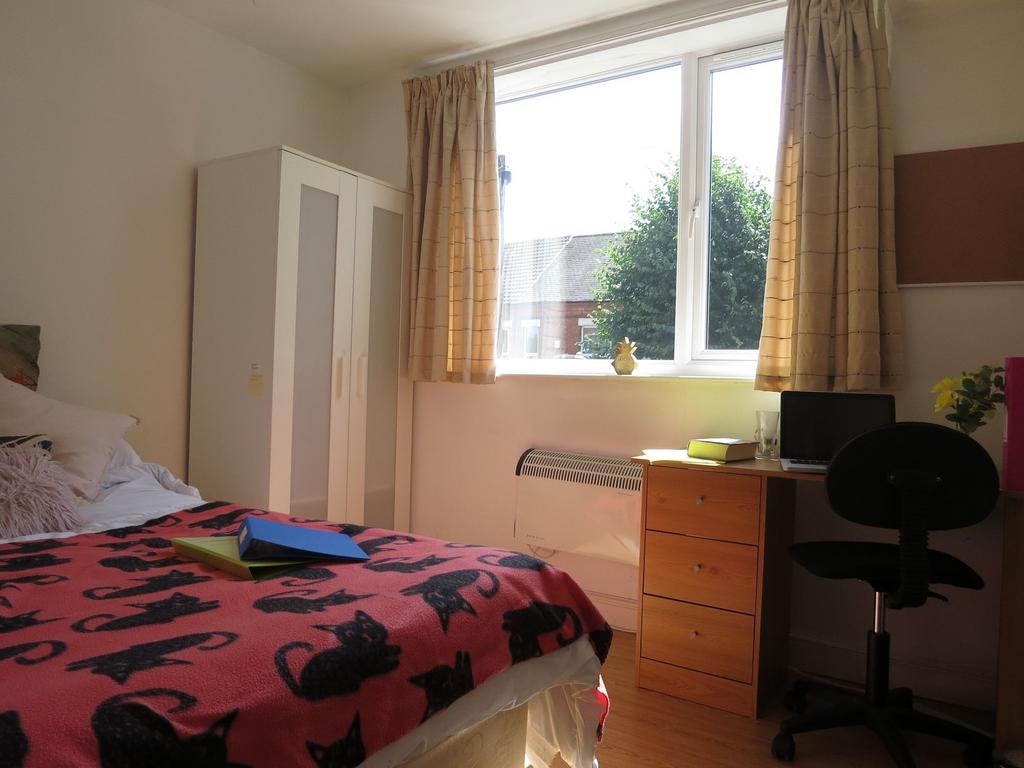 Bright double bedroom with a large window, simp...
