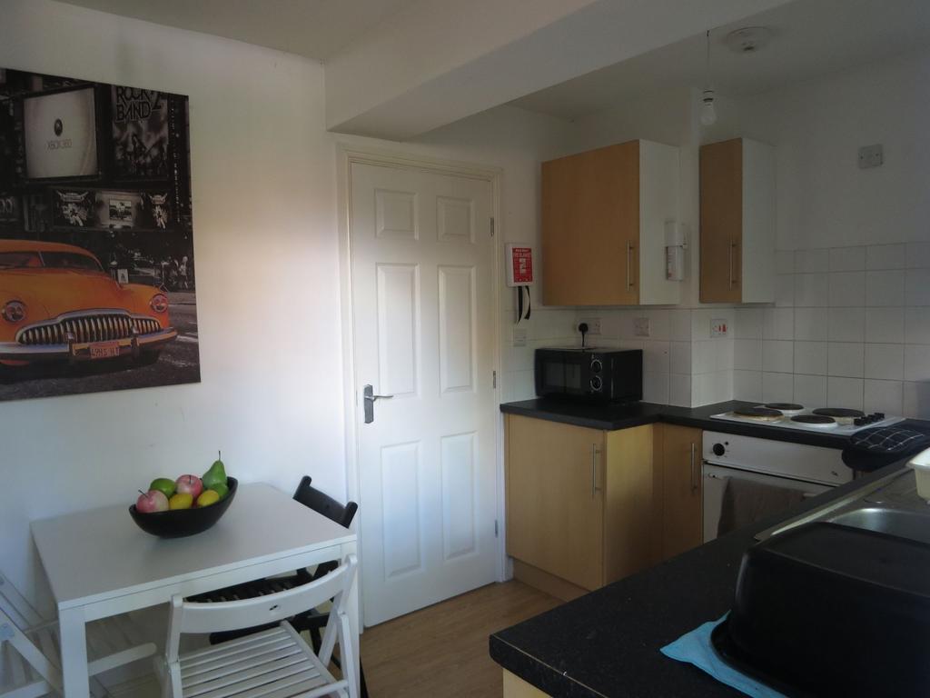 Bright, tidy kitchen with light wood cabinets, ...