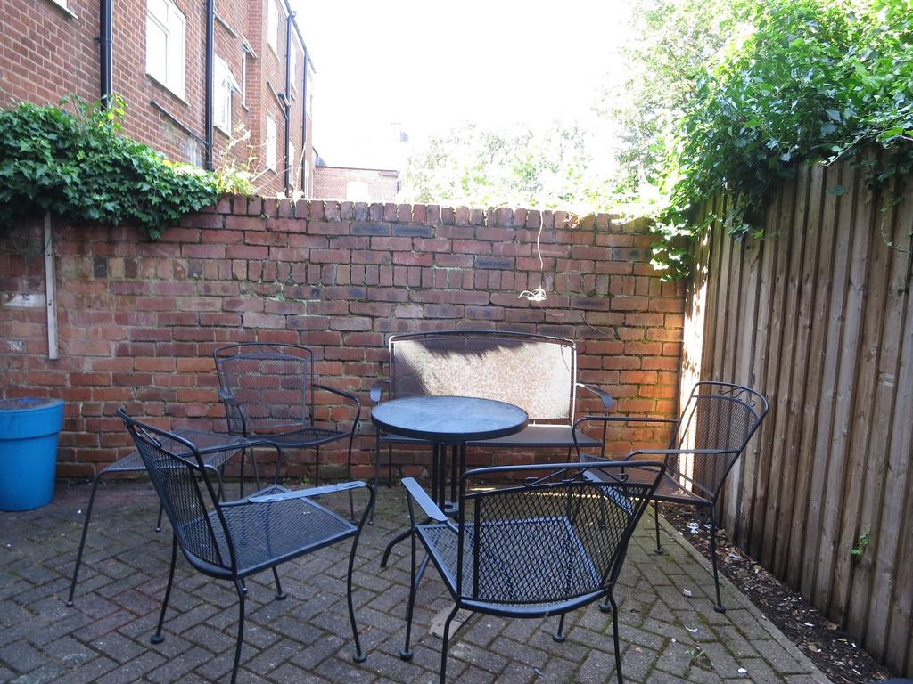 Sunny private paved courtyard with metal outdoo...