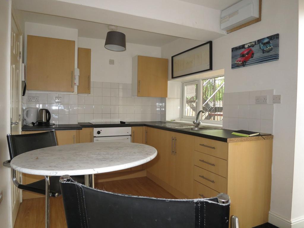 Well-equipped galley kitchen featuring light wo...