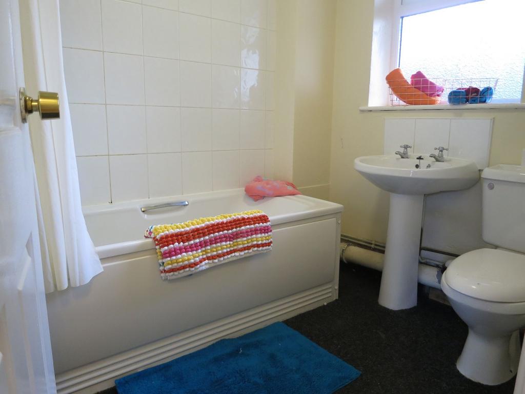 Clean, functional bathroom with a white bath an...